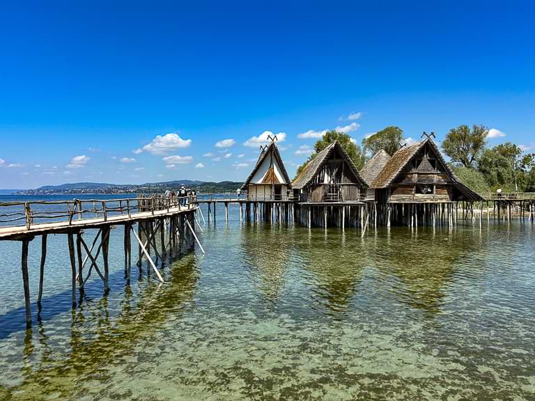 Ein Rundweg über hölzerne Stege führt vorbei an den überm Wasser errichteten Pfahlbauten