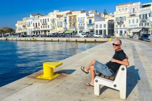 Heiko Meyer auf einer Bank an der Hafenpromenade von Ermoupolis auf der griechischen Kykladeninsel Syros