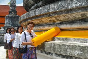 Gläubige umspannen den Chedi mit einem orangenen Tuch, Wat Phra Mahathat Woramaha Viharn, Nakhon Si Thammarat